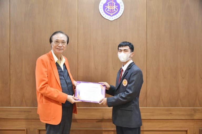 Mr. Petpoom Maneewan receiving the Certificate of Internship Program Completion from WU President